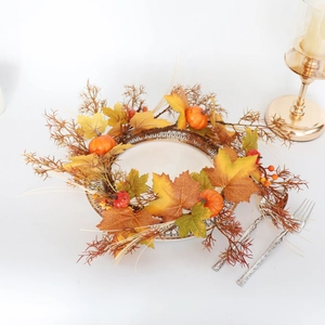 Macro view of autumn candle ring with colorful maple leaves, mini pumpkins and red berries