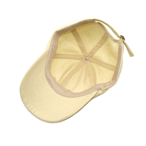 Inside view of beige cotton baseball cap showing internal stitching and metal buckle