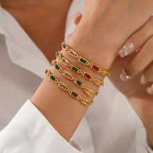 Dettaglio del bracciale a doppia catena in oro con vivaci gemme colorate dal taglio baguette