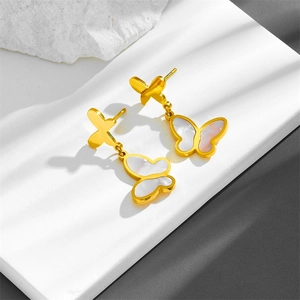 Elegant gold stainless steel butterfly earrings with white shell tassel on stone surface
