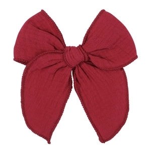 Detailed macro view of 5.4-inch red jacquard cotton bow hair clip with textured fabric
