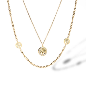 Macro detail of gold tree of life pendant with pavé cubic zirconia on layered chain
