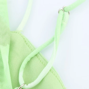 Détail macro des bretelles de robe vert clair avec boucles de réglage en métal argenté