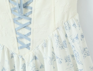 Détail de la robe à imprimé toile avec taille lacée et tissu jacquard à fleurs bleues