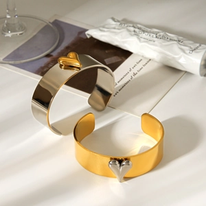 Close-up of two-tone stainless steel heart bangles with polished wide open design