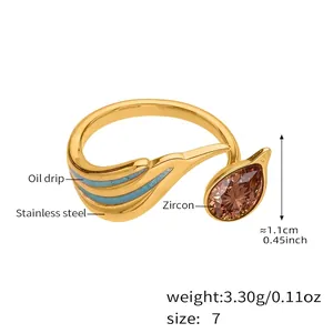 Detail view of gold stainless steel ring with pear-cut zircon and blue oil drip finish