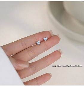 Close-up of small S925 sterling silver butterfly studs with blue enamel finish