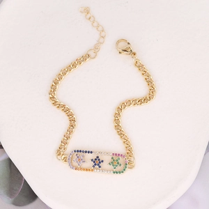 Macro view of gold Cuban chain bracelet featuring colorful zircon inlaid stars