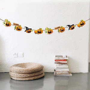 Close-up of Halloween banner featuring orange pumpkins and witch hats on a white wall