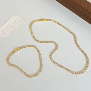 Elegant gold tennis chain jewelry set with necklace and bracelet featuring shiny zircons