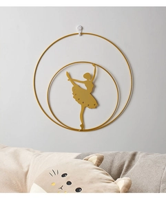 Detailed view of a golden metal wall decor featuring a ballet dancer silhouette