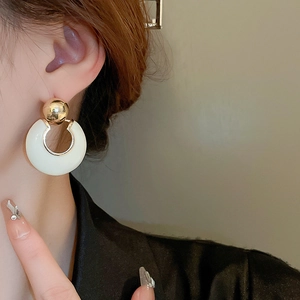 French luxury C-shaped hoop earring in cream white enamel and gold beads on model
