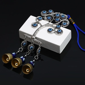 Detailed view of evil eye tree ornament with blue glass beads and small brass bells