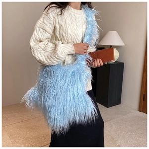 Stylish blue faux fur shoulder bag worn by a model in a cozy interior setting