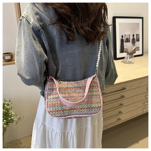 Close-up of colorful woven shoulder bag featuring butterfly embroidery and pearl strap