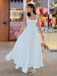 Détail d'une robe blanche sans manches avec col carré, taille en V et jupe ligne A fluide