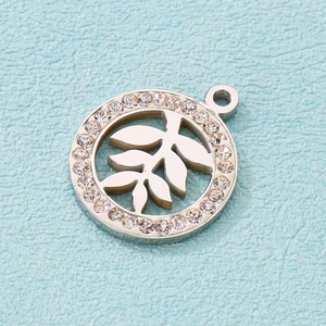 Macro view of a silver circular leaf pendant with hollow design and crystal rhinestones