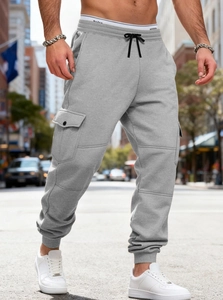 Detail of light grey cargo sweatpants showing side flap pocket and soft cotton texture