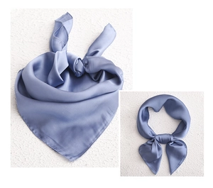 Detail showing blue silk texture scarf tied in two elegant styles on textured surface