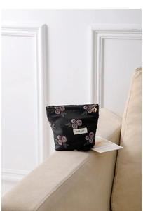 Detail of vintage black jacquard cosmetic bag with pink roses and gold star zipper