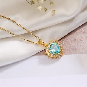 Detail view of heart-shaped blue gemstone pendant with gold chain on silk
