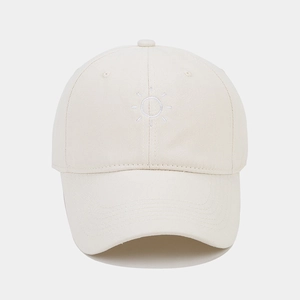 Close-up of minimalist sun embroidery on beige soft top baseball cap with curved brim