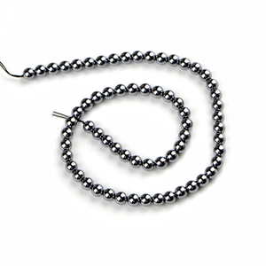 Polished Terahertz round stone beads spiraled on a white background for jewelry making