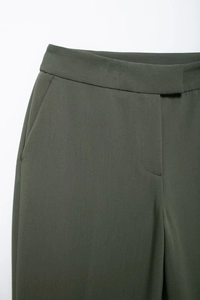 Détails du pantalon de costume vert armée montrant la taille et la poche latérale