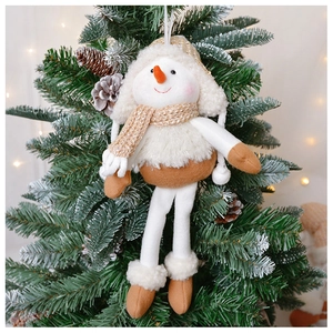 Close-up of a handmade knitted snowman plush hanging on a green Christmas tree