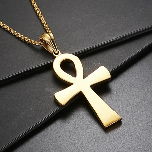 Détail du collier croix Ankh dorée avec des gravures de hiéroglyphes égyptiens
