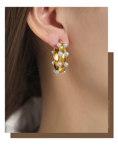 Close-up of vintage gold-plated hoop earrings with high-lustre shell pearls on model