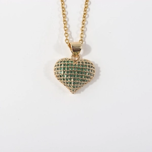 Detailed macro view of gold plated heart pendant with vibrant green pavé cubic zirconia