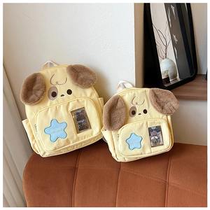 Close-up of yellow dog canvas backpack with plush ears and blue star pocket detail