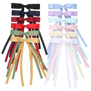 Detailed view of 12 multi-colored satin ribbon bow hair clips on white background