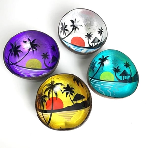 Top view of four handcrafted coconut bowls with colorful tropical sunset lacquer interior