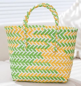 Detailed close-up of the woven texture on a green and yellow handmade gift basket bag