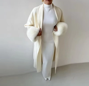 Detail of white long wool coat featuring luxurious faux fur cuffs and elegant long sleeves