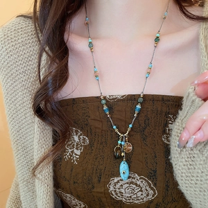 Dettaglio di collana vintage con perline turchesi e rosa in stile bohémien