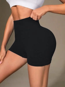 Detail of high waisted seamless black yoga shorts with ribbed texture for tummy control