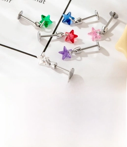 Detail of star-shaped stainless steel ear studs with colorful zircon inlays and flat back