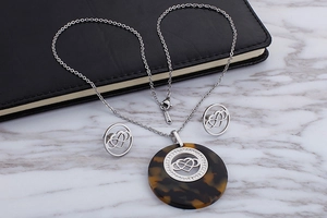 Detail of tortoise shell necklace with crystal heart and infinity symbol in stainless steel