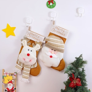 Christmas stockings with Santa and reindeer motifs hanging on a festive decorated wall