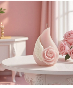 Detail of pink teardrop candle featuring delicate rose and wing relief carvings