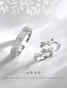 Detailed close-up of tree bark texture and twig design on silver couple rings