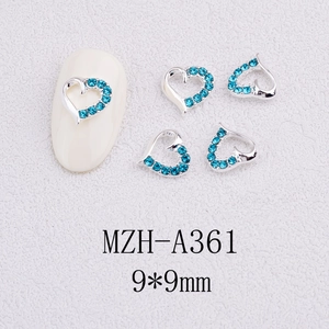 Macro detail of blue crystal heart nail charm with silver alloy frame and 9x9mm size