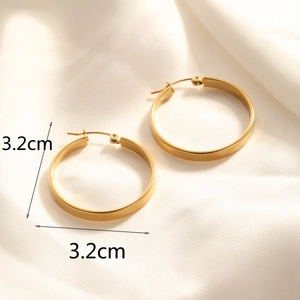 Detailed view of 3.2cm golden hoop earrings on silk fabric showing the secure clasp