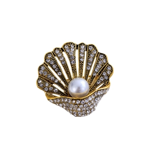 Vintage shell brooch in gold metal with rhinestones and a large center pearl