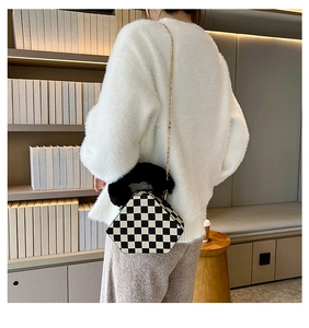 Detail of checkered geometric bag with plush black faux fur handle and gold chain strap