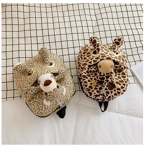 Detail of plush animal backpacks featuring leopard and giraffe prints for kids