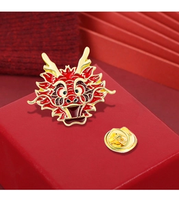 Detail of cartoon Chinese dragon brooch with red enamel and gold metallic finish